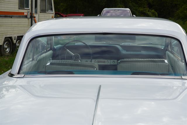 Streak-free windscreen of a white Chevrolet Impala, looking through to the interior.