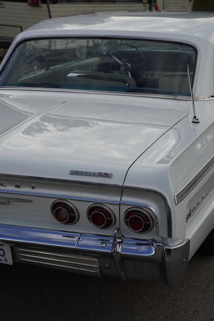Rear quarter of a white Chevrolet Impala SS showing the badge and triple round tail lights.